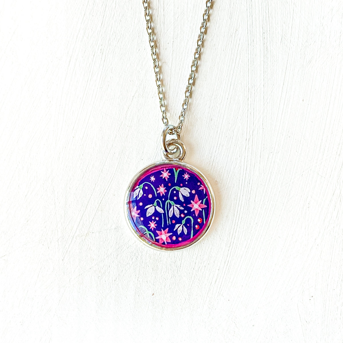 a necklace with a picture of a flower on it