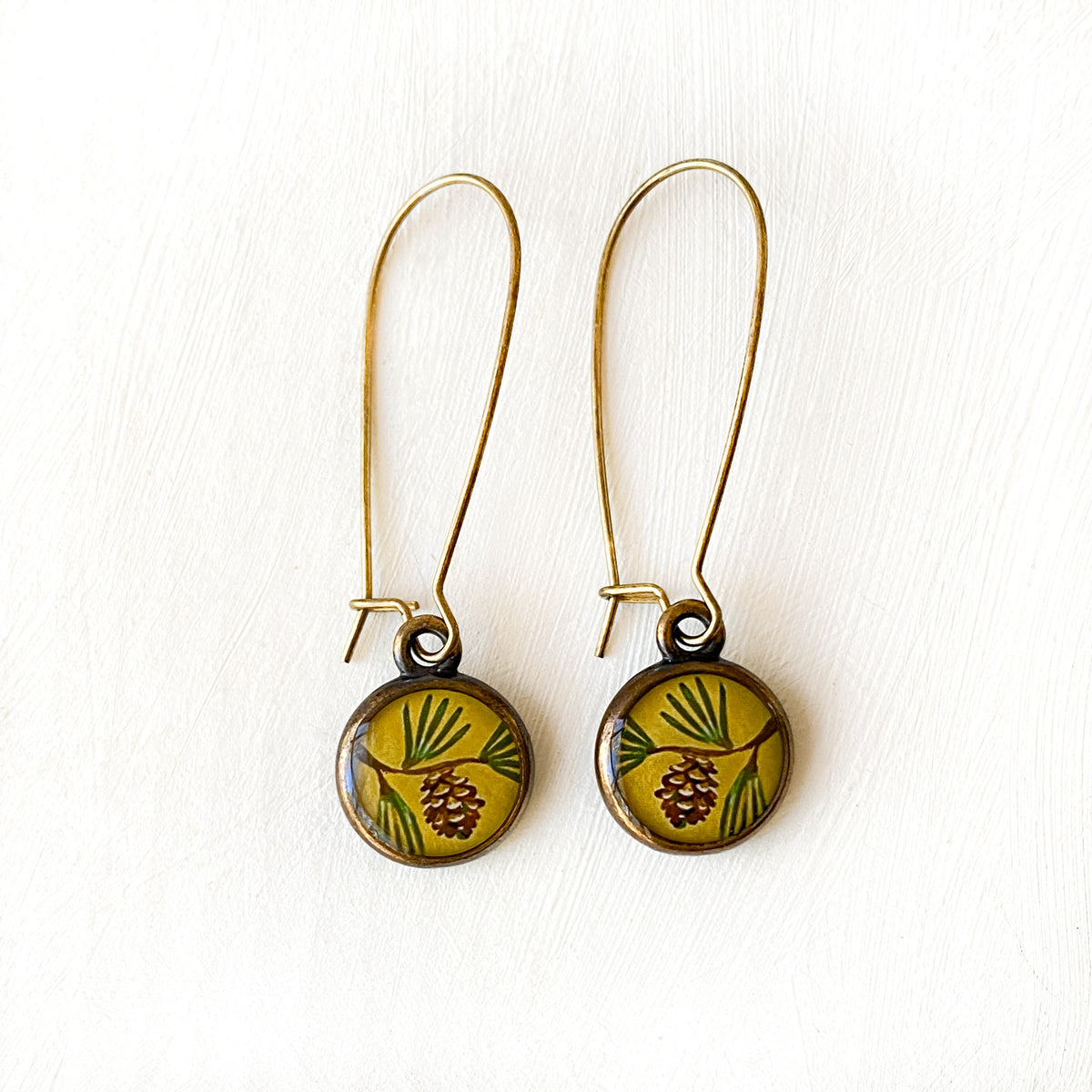 a pair of earrings with a flower design on them