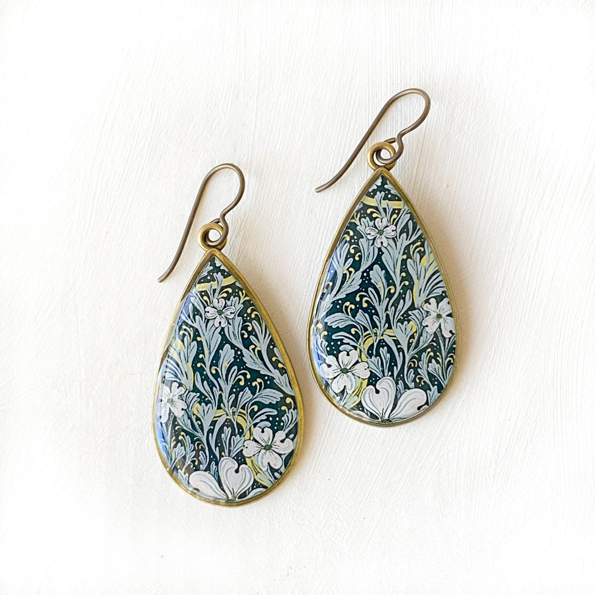 a pair of blue and white earrings on a white surface