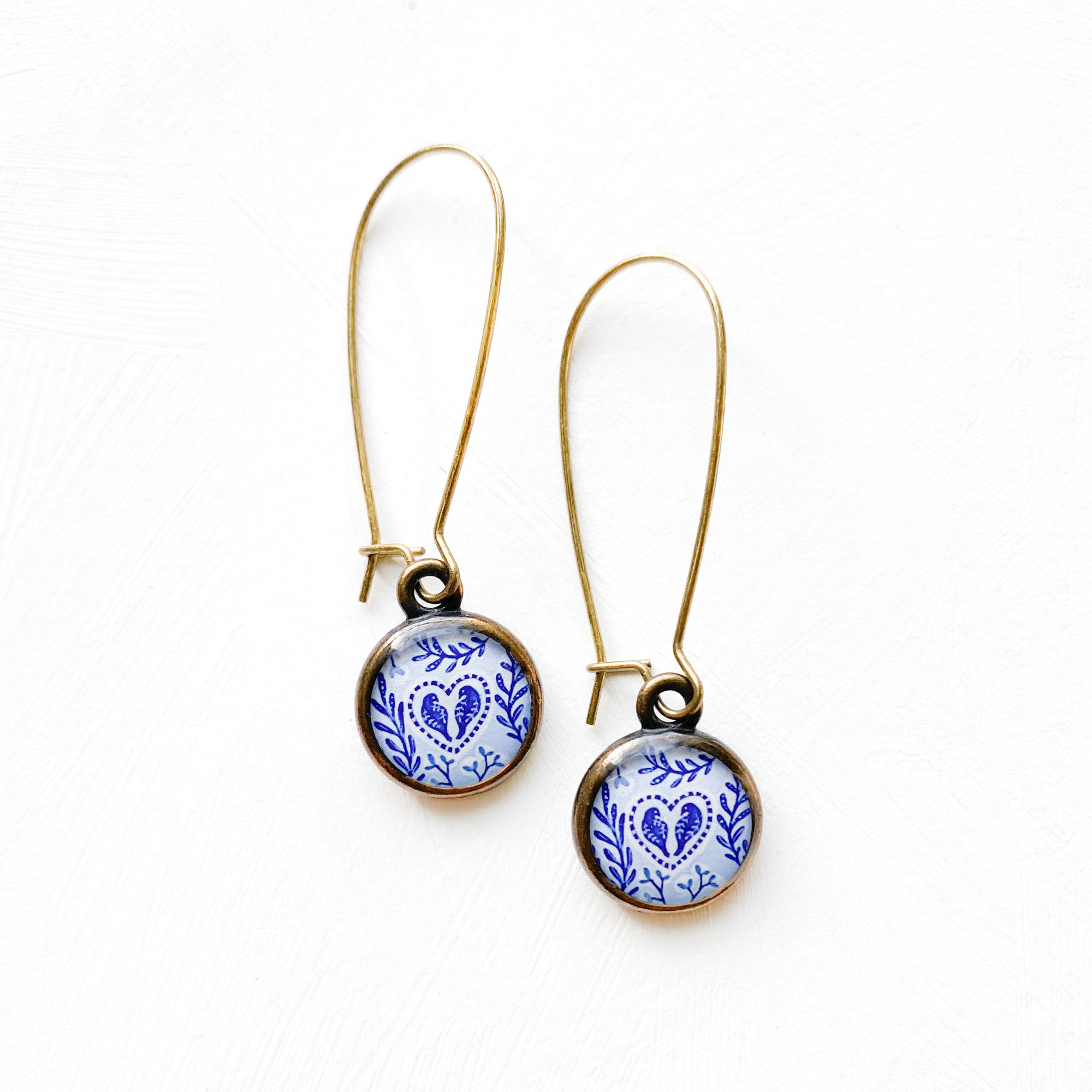 a pair of earrings with blue and white designs