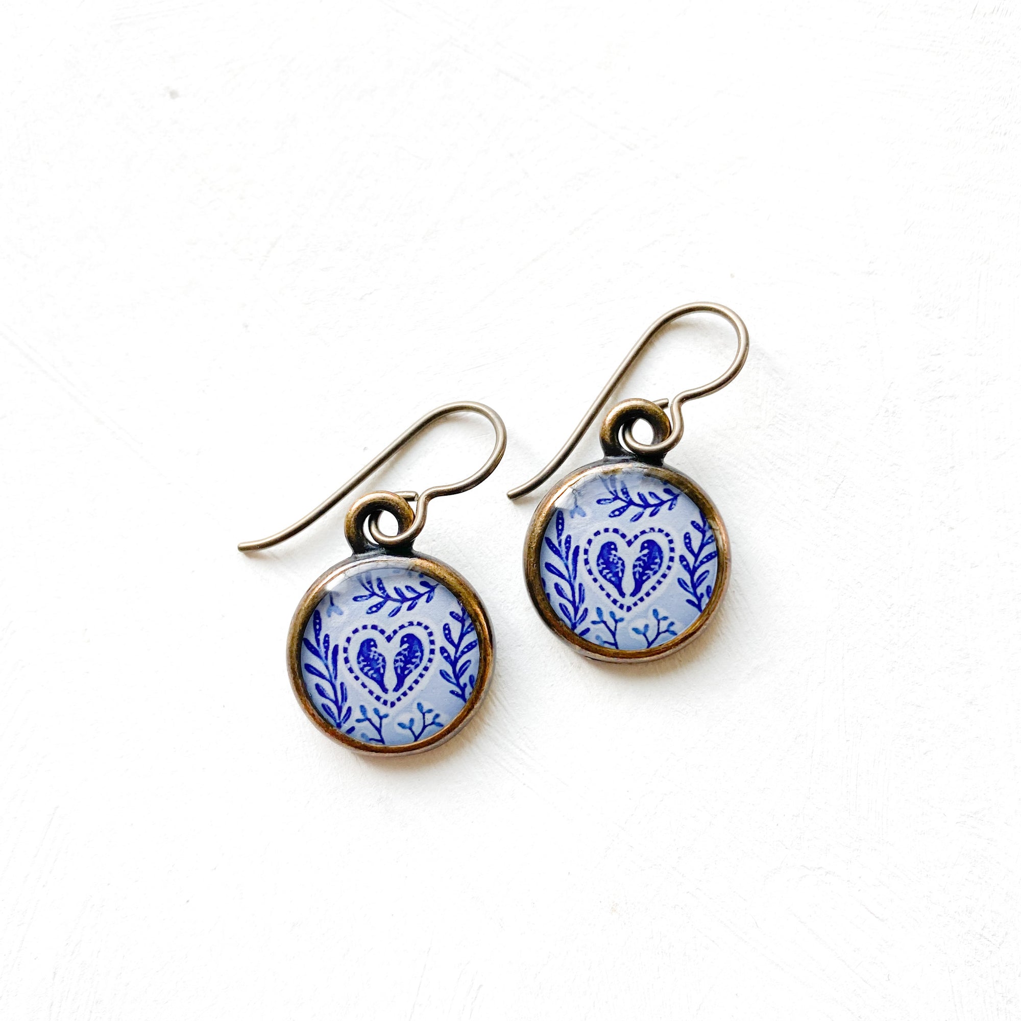 a pair of earrings with blue and white designs