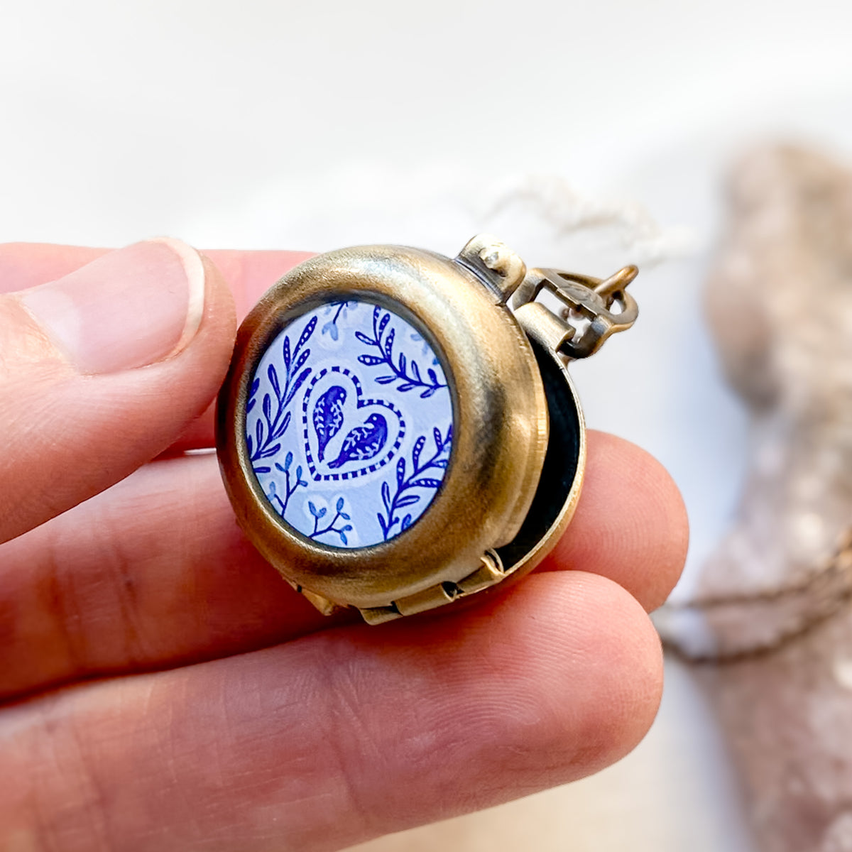 a person holding a small pocket watch in their hand