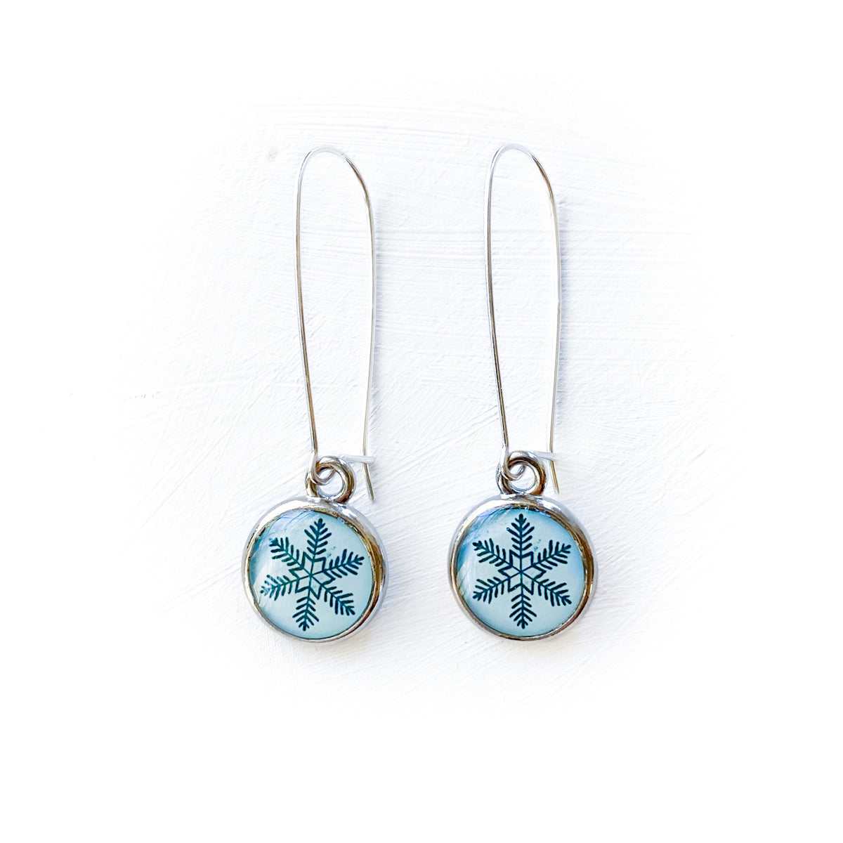 a pair of earrings with a snowflake design