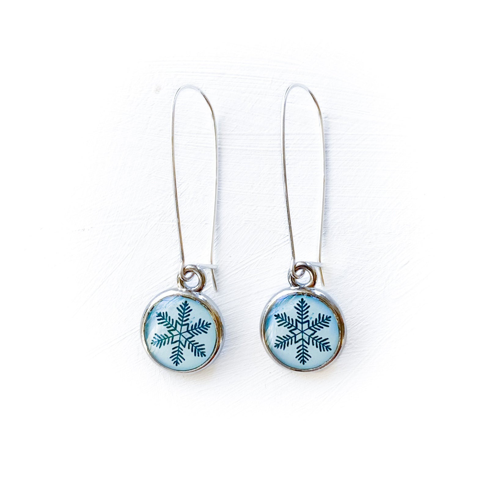 a pair of earrings with a snowflake design