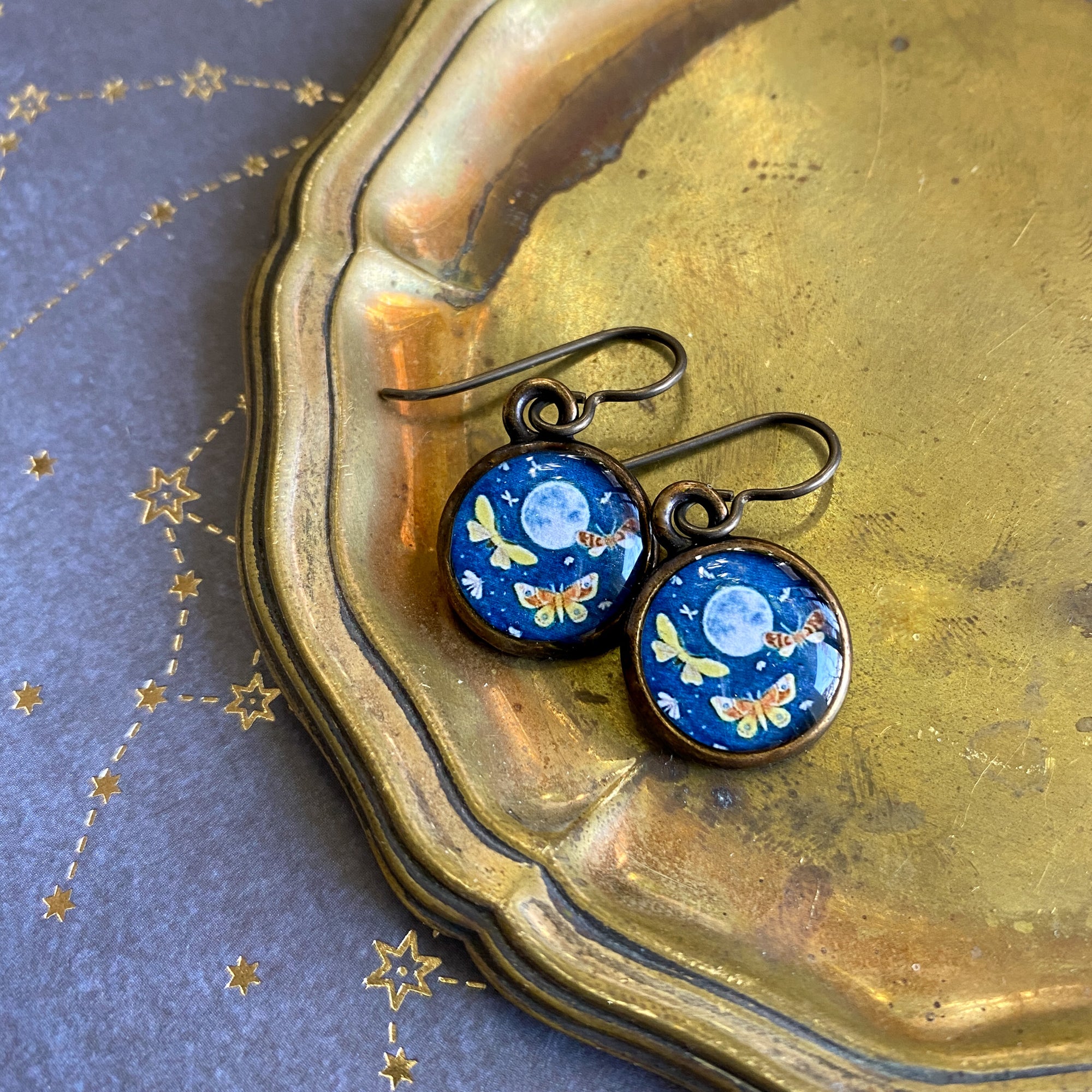 a pair of earrings with a blue background