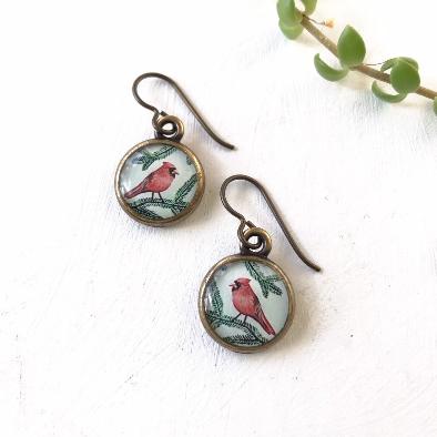 a pair of earrings with a bird on it