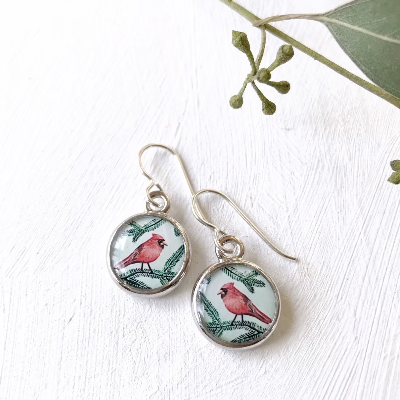 a pair of earrings with a red bird on it