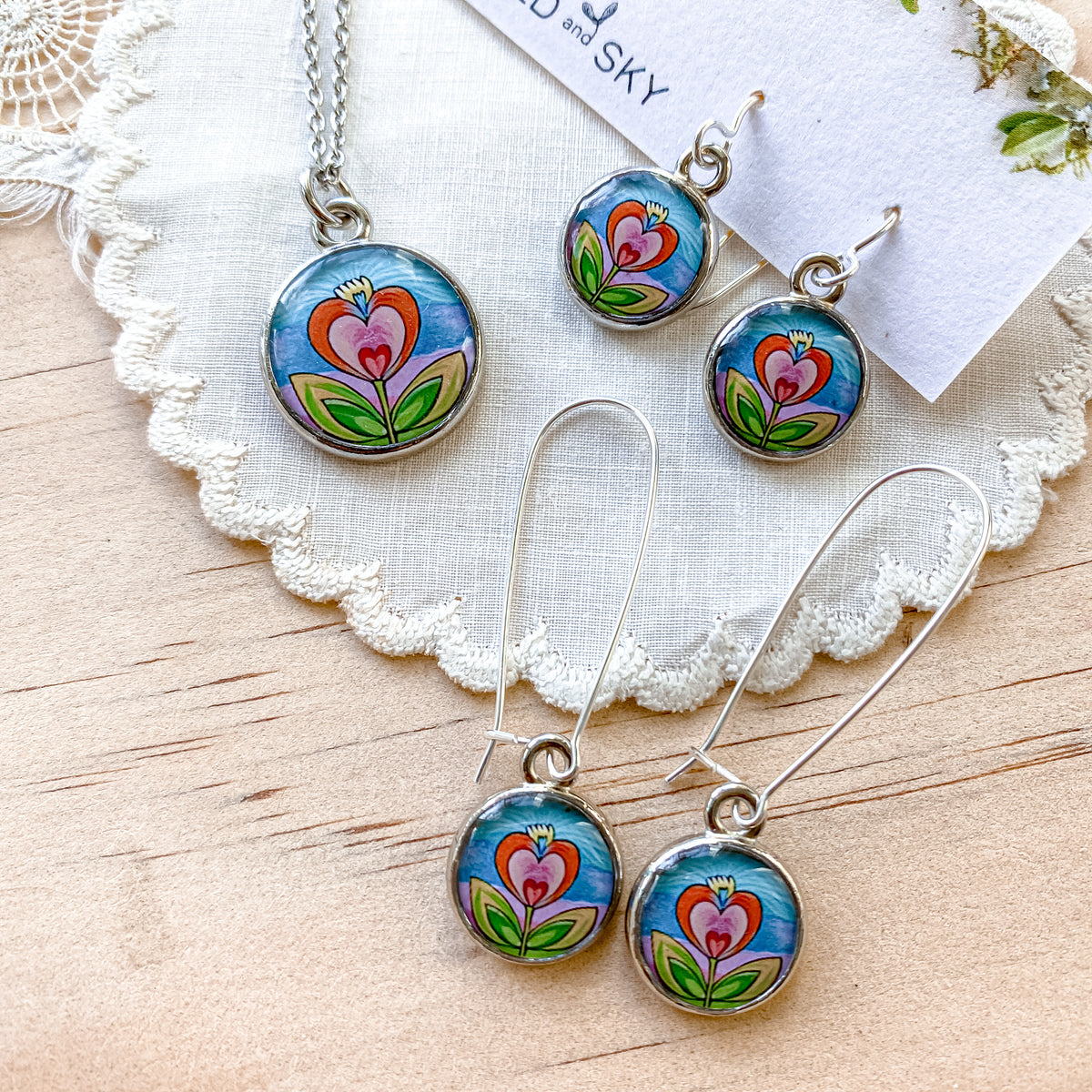 a set of three necklaces and earrings on a doily