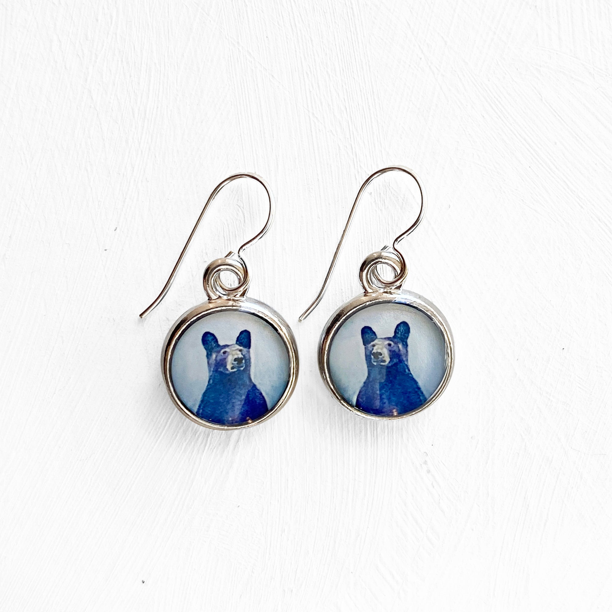a pair of earrings with a picture of a dog