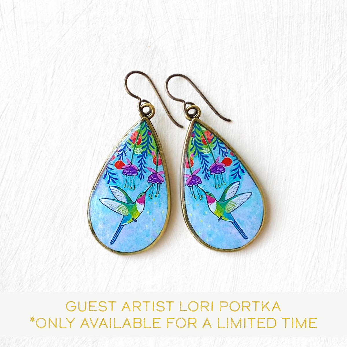 a pair of earrings with a picture of a bird on it