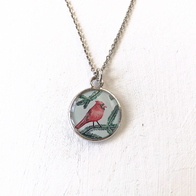 a red bird sitting on top of a tree branch