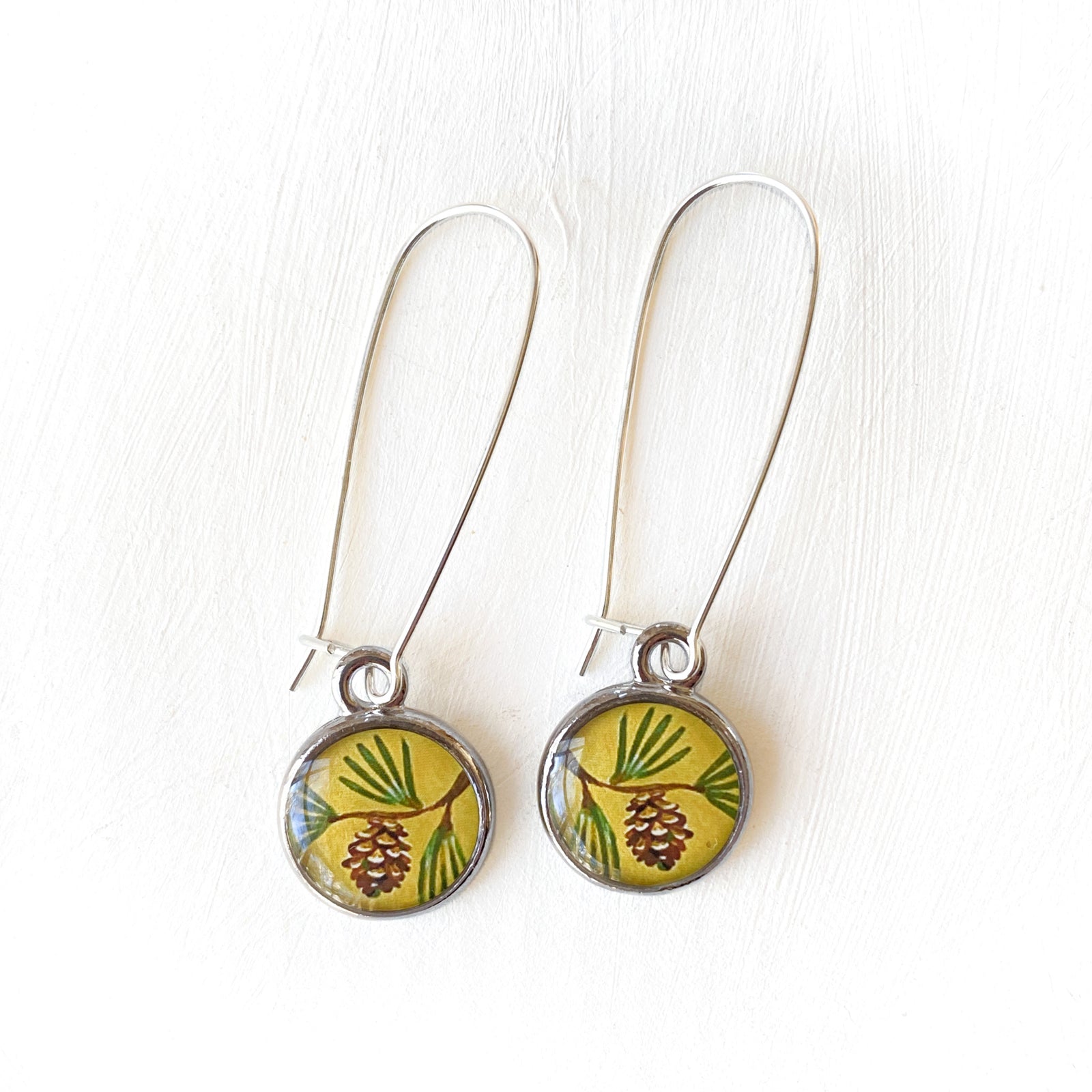 a pair of earrings sitting on top of a white table