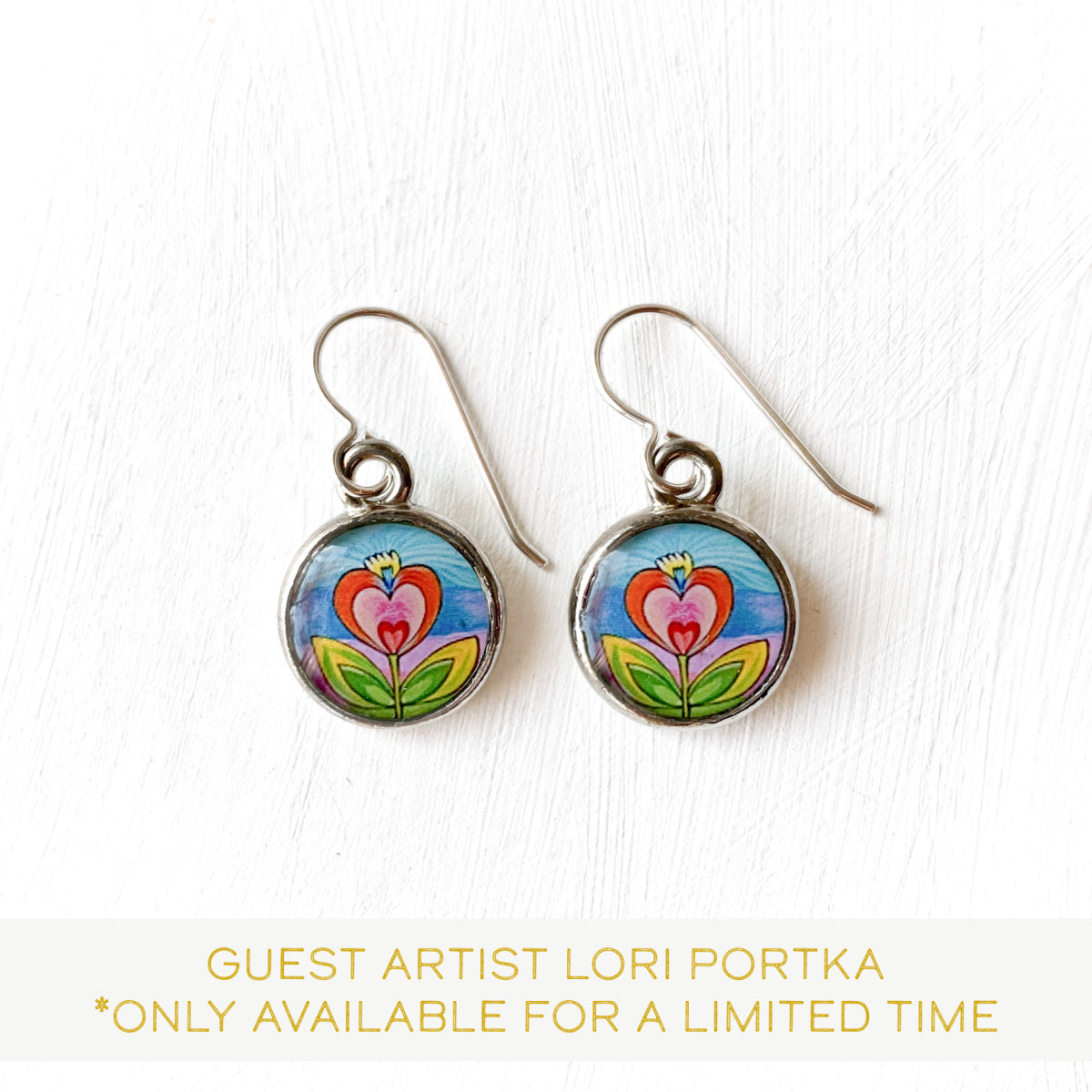 a pair of earrings with flowers painted on them