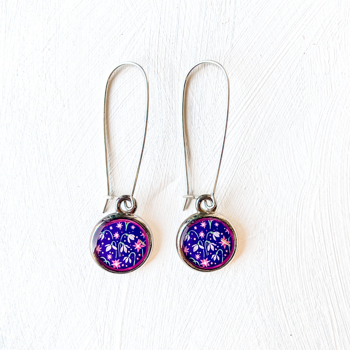 a pair of earrings with a purple and blue design