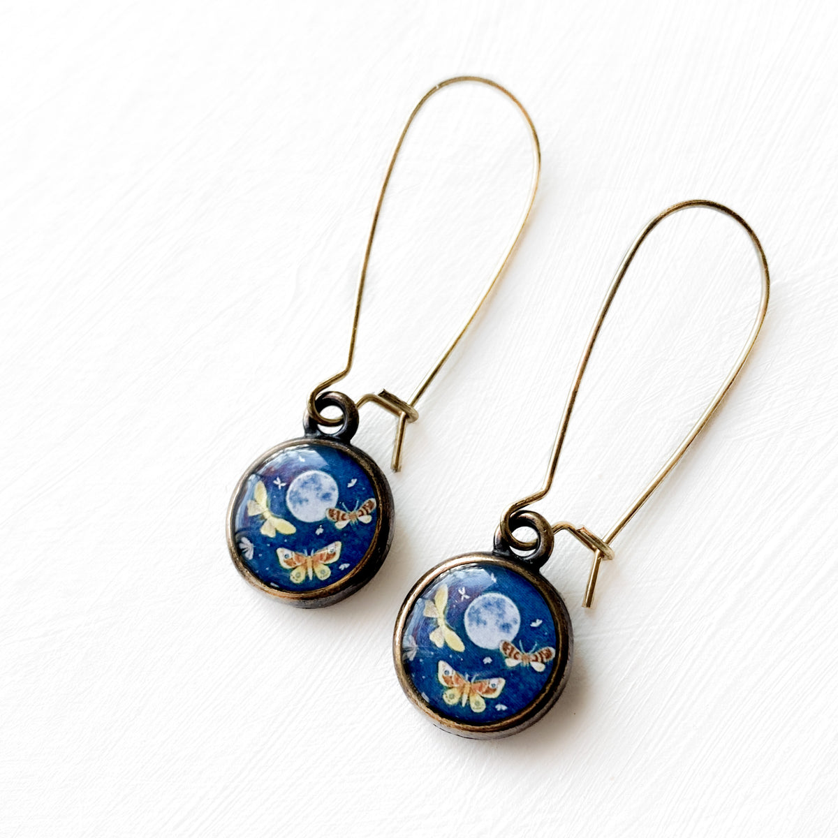 a pair of earrings with a butterfly design on them