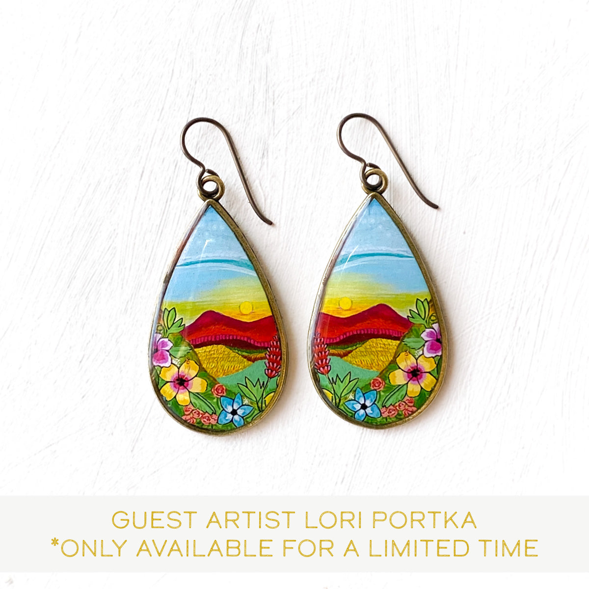 a pair of earrings with a painting on them
