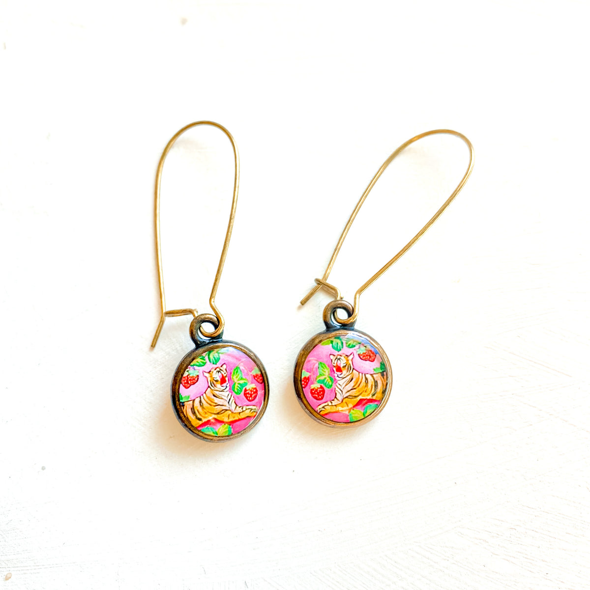 a pair of earrings with colorful designs on them